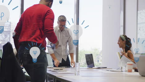 Animation-of-lightbulb-icons-over-diverse-colleagues-talking-in-office