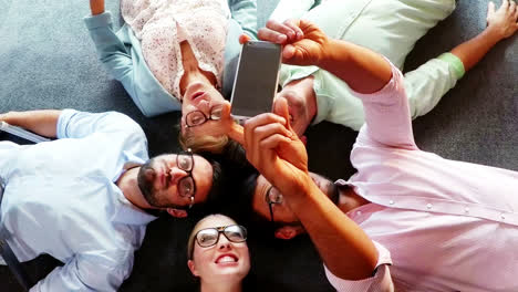 Grupo-De-Ejecutivos-De-Negocios-Tomando-Selfie-Desde-Un-Teléfono-Móvil