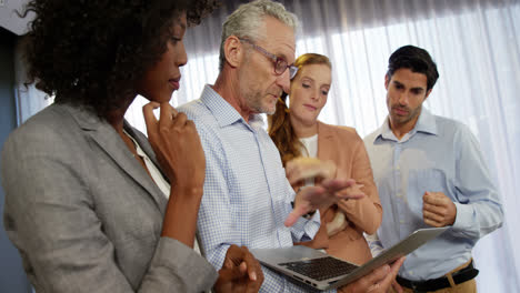 Business-people-discussing-over-laptop