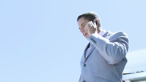 Businessman-speaking-on-phone-outdoors