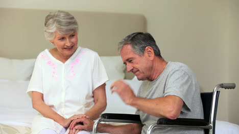 Woman-trying-to-comfort-depressed-man-in-wheelchair