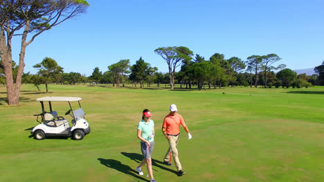 Longitud-Completa-De-Una-Pareja-De-Golfistas-Maduros-En-Un-Carrito-De-Golf