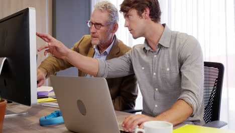 Businessman-interacting-with-his-coworker-while-working