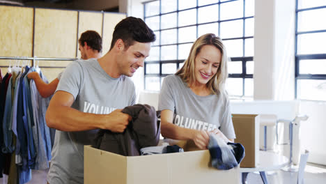 Voluntarios-Revisando-Caja-De-Donación-De-Ropa.