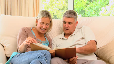 Couple-on-sofa-looking-through-an-album-