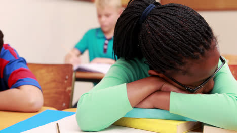 Little-girl-sleeping-on-a-book-in-classroom