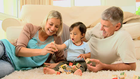 Doting-parents-laughing-with-baby-on-carpet