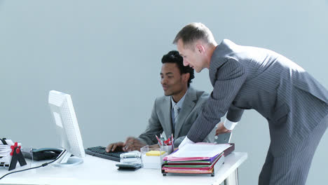 AfroAmerican-and-Caucasian-businessmen-working-together-in-office