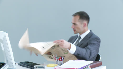 Hombre-De-Negocios-En-La-Oficina-Leyendo-Un-Periódico-Y-Hablando-Por-Teléfono