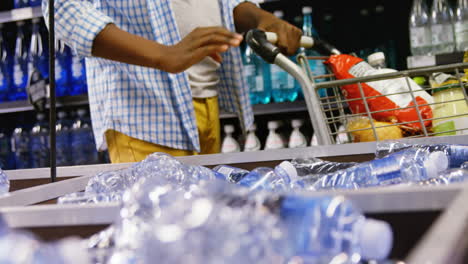 Hombre-Comprando-Una-Botella-De-Agua-En-La-Sección-De-Comestibles.