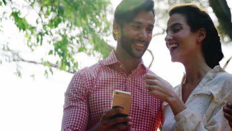 Couple-using-mobile-phone-while-having-glass-of-drink