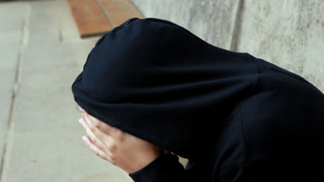 Schoolgirl-in-hooded-sitting-alone-at-school