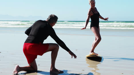 Senior-man-training-woman-on-beach