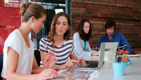 Group-of-graphic-designer-interacting-while-using-laptop