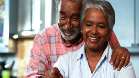 Senior-couple-using-laptop-in-the-kitchen