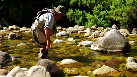 Fly-fisherman-searching-fish-in-shallow-river-water