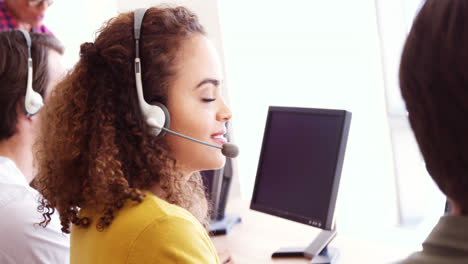 Portrait-of-smiling-customer-service-executive-working-at-desk