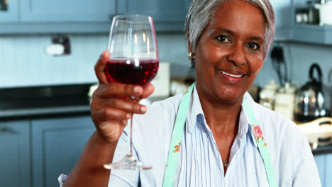 Mujer-Mayor-Tomando-Vino-En-La-Cocina