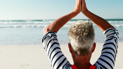 Senior-woman-doing-yoga-on-the-beach