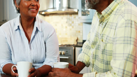 Senior-couple-having-coffee-in-kitchen