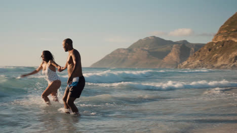 Pareja-Jugando-En-La-Playa