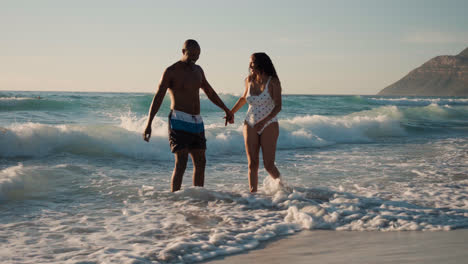 Pareja-Jugando-En-La-Playa