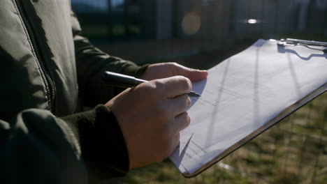 Man-signing-certificate-outdoors