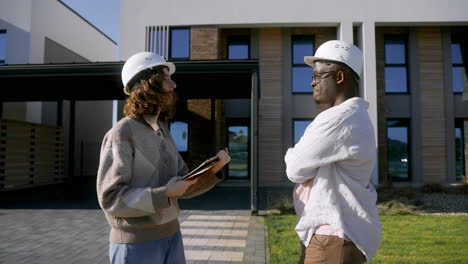 Man-and-woman-with-hardhats-handshaking-at-the-front-yard