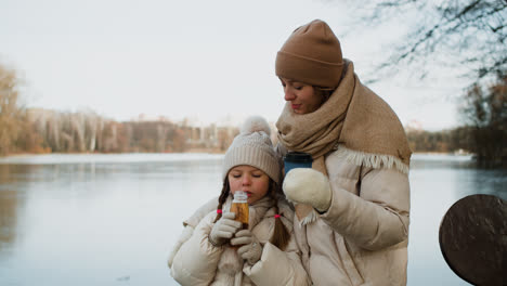 Mamá-E-Hija-Bebiendo-Al-Aire-Libre