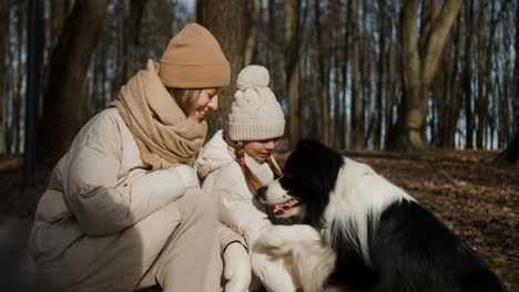 Mom-and-daughter-playing-with-dog