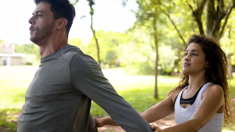 Woman-helping-man-with-the-stretching-outdoors