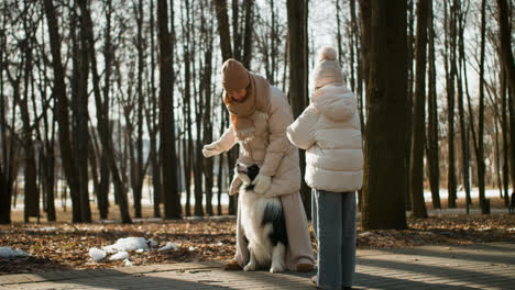 Mom-and-daughter-playing-with-dog