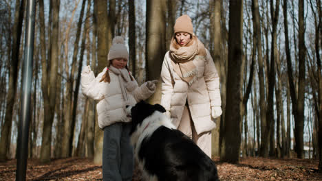 Mom-and-daughter-playing-with-dog