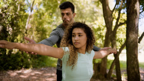 Hombre-Ayudando-A-Mujer-Con-Los-Estiramientos-Al-Aire-Libre