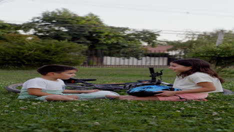 Girl-putting-bike-helmet-on-her-little-brother