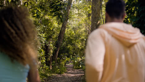 Young-couple-running-in-the-forest