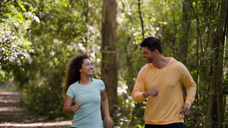 Glückliches-Paar-Läuft-Im-Wald