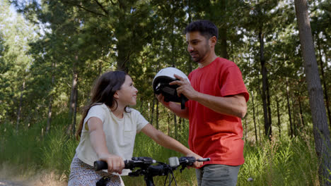 Vater-Setzt-Tochter-Helm-Auf