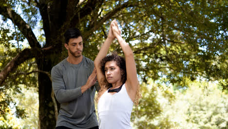 Man-helping-woman-with-the-stretching-outdoors