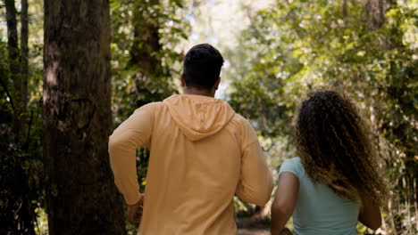 Young-couple-running-in-the-forest