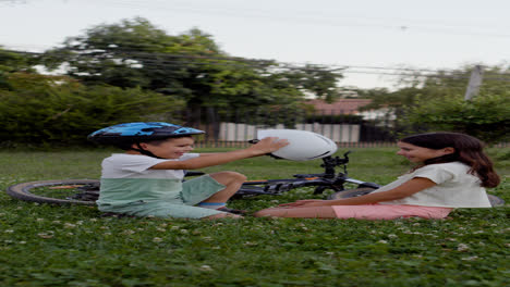 Niño-Poniéndole-Un-Casco-De-Bicicleta-A-Su-Hermana