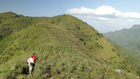 A-tribal-man-guides-a-tourist-along-a-mountain-track-in-Uganda