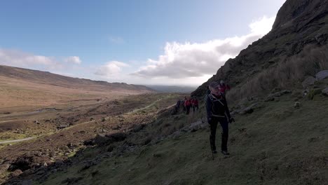 hill-walkers-on-mountain-with-winter-sun-Comeragh-mountains-Waterford-Ireland