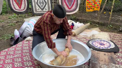 Anciano-Artista-Hace-Alfombra-Tradicional-Alfombra-De-Lana-Hecha-A-Mano-Hecha-Con-Fibra-De-Lana-Diseño-Colorido-Patrón-Antiguo-Local-Mezcla-Material-De-Lana-Rollo-De-Prensa-Amasar-En-Agua-Fieltro-Habilidad-Para-Golpear-Comprimir-En-Irán