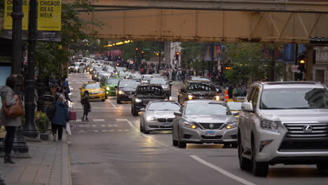 Busy-morning-traffic-with-pedestrians-in-downtown-Chicago-on-a-cloudy-day,-4K-handheld-slow-motion