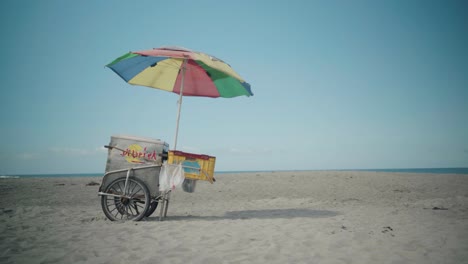 Puesto-De-Helados-Con-Coloridas-Sombrillas-En-Una-Playa-Aislada