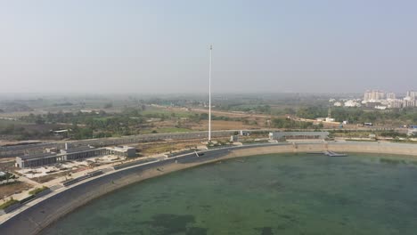 Drohnenansicht-Des-Rajkot-Atal-Sees.-Viele-Straßen-Verlaufen-Dahinter-Und-Ein-Großes-Feld-Ist-Auch-Sichtbar,-Die-Neue-Rennstrecke-Von-Rajkot,-Atal-Sarovar