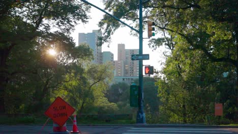 Morgenjogger-Passieren-Im-Central-Park-Mit-Manhattan-Skyline-Hintergrund-Ein-„Slow-Down“-Schild