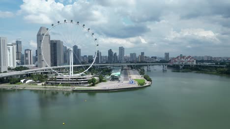 Drone-shot-of-Marina-Promenade-and-Singapore-Flyer-Eye,-camera-orbiting-around-Marina-Bay-F1-track