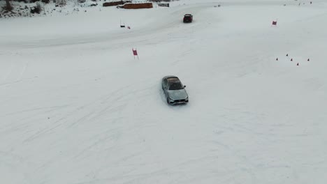 Blick-Von-Oben-Auf-Das-Auto,-Das-Ein-Driftmanöver-Auf-Einer-Verschneiten-Winterrennstrecke-Durchführt